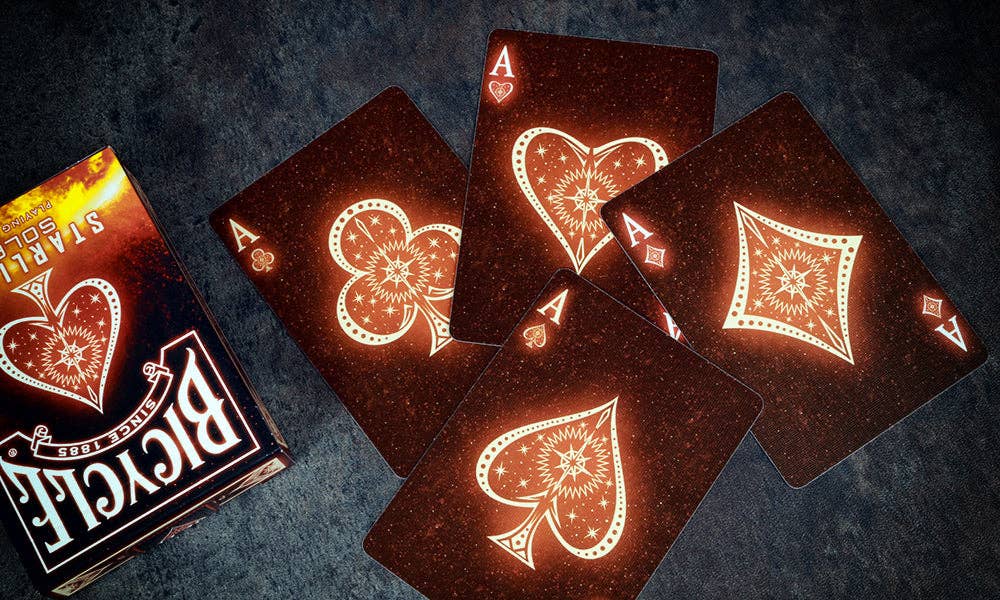 Bicycle playing cards with intricate designs on a dark textured surface