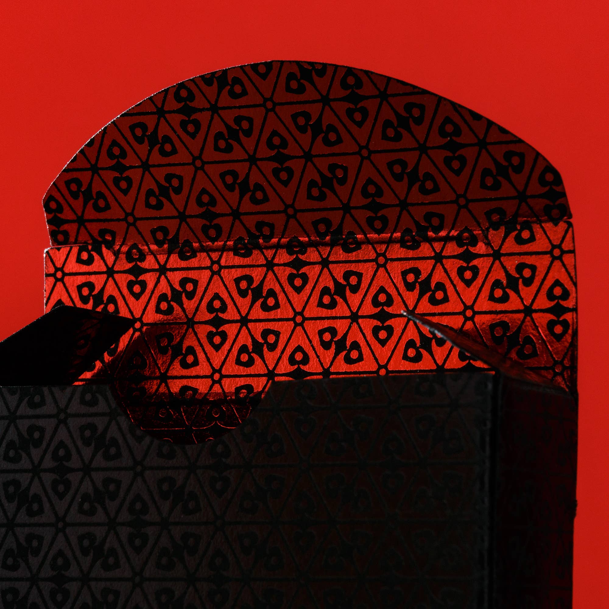 Black geometric-patterned box on a red background