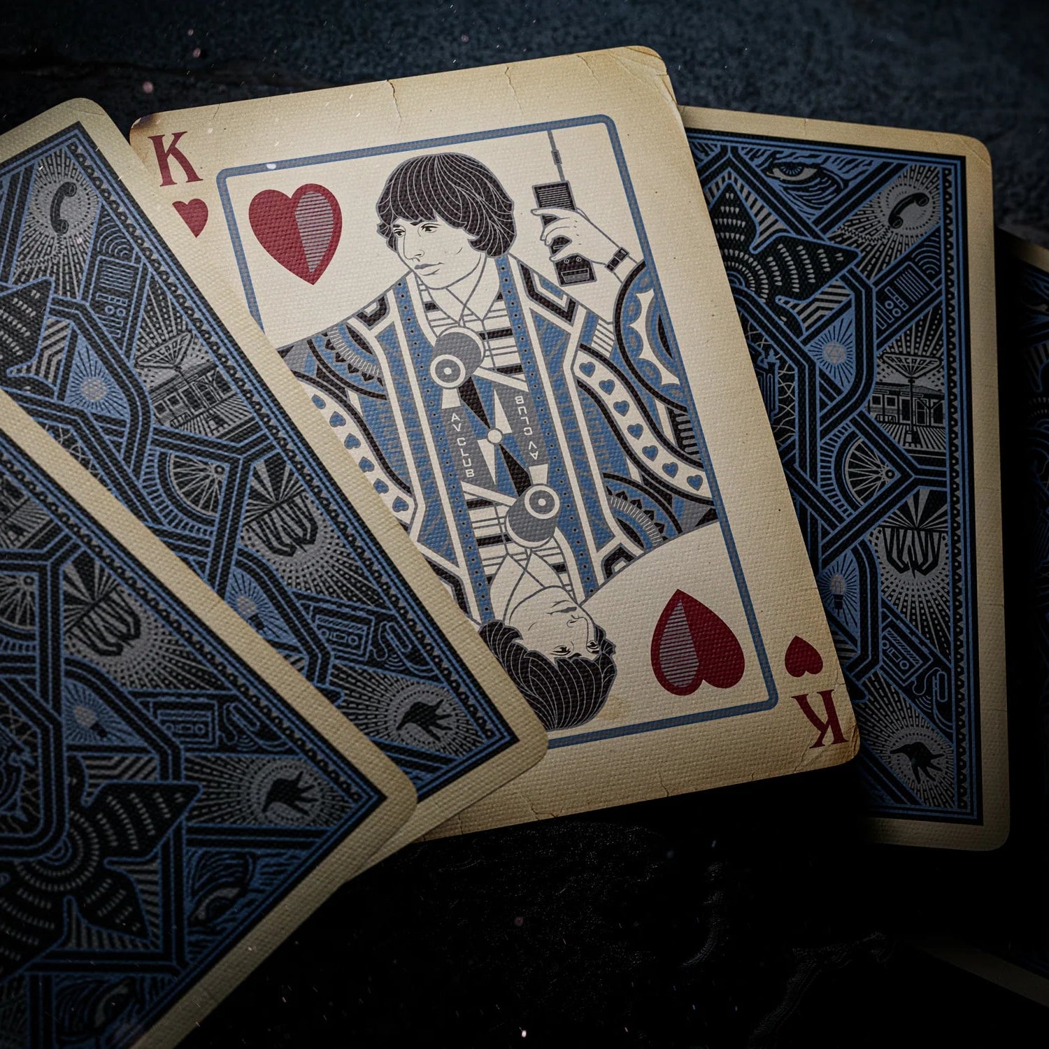 Stranger Things Hive Mind Playing card with a stylized illustration of a character holding a heart, surrounded by blue and black geometric patterns.