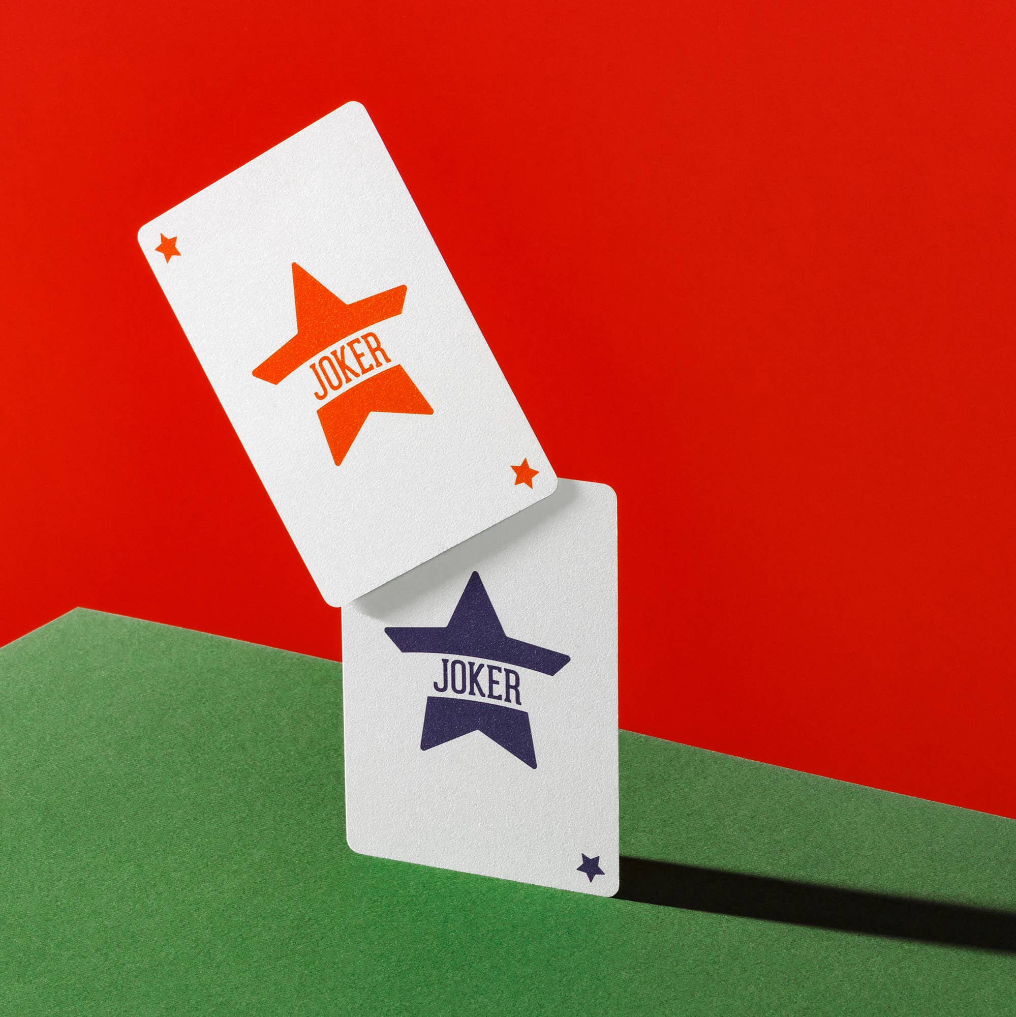 Two Vanda Aces Red joker cards with star designs on a red and green background