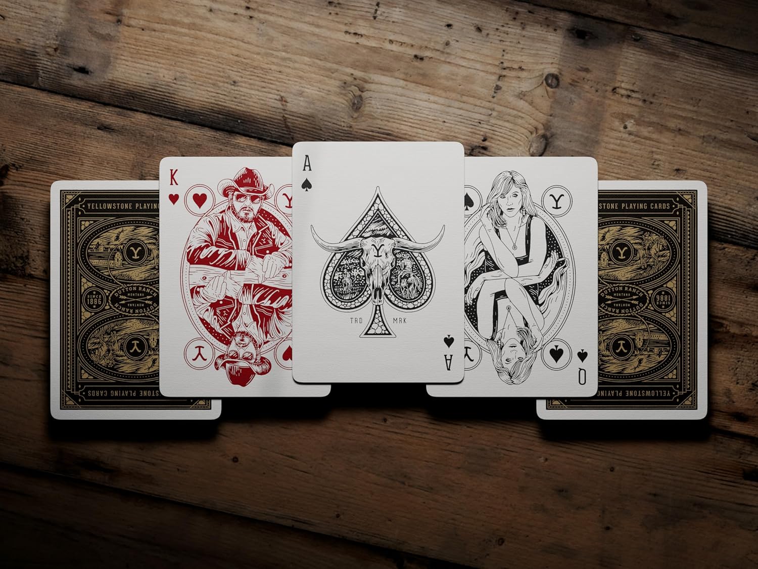 Four playing cards displayed on a wooden surface