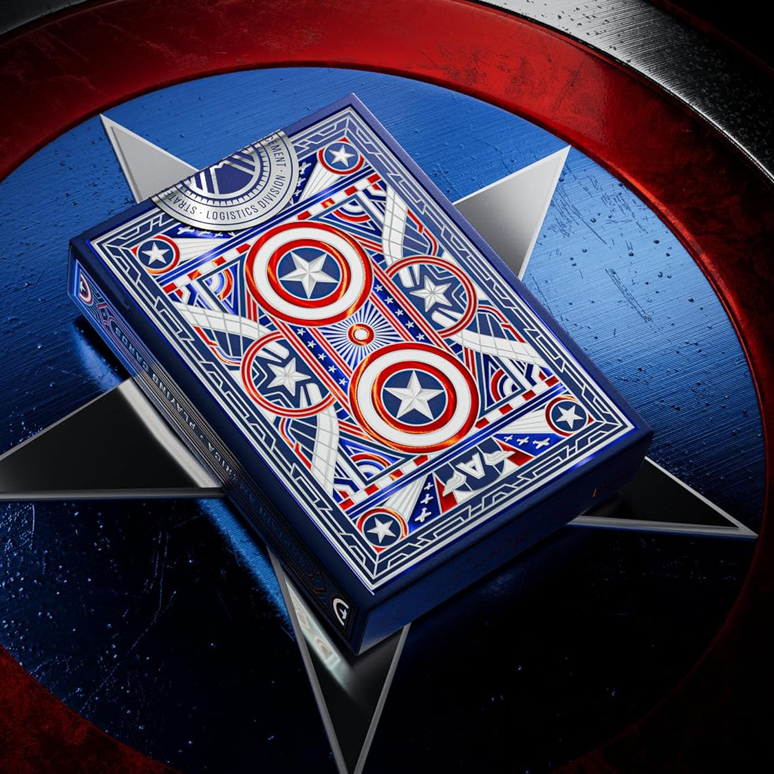 Theory11 Captain America tuck box resting on a large metal Captain America shield, showing intricate blue, red, and silver back design.
