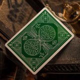 Green playing card with a clover symbol on a wooden surface