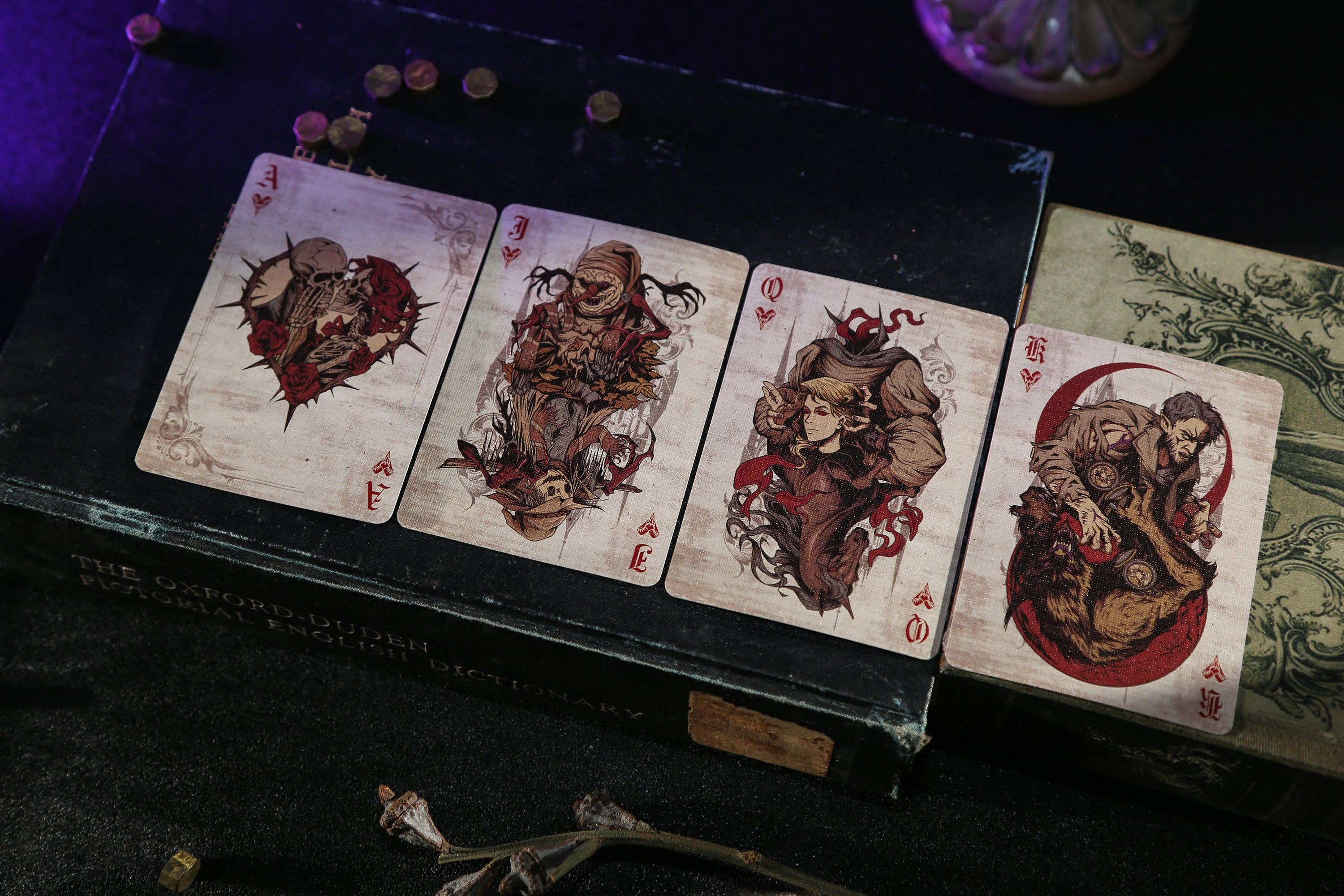 Four tarot cards with artistic designs on a dark surface