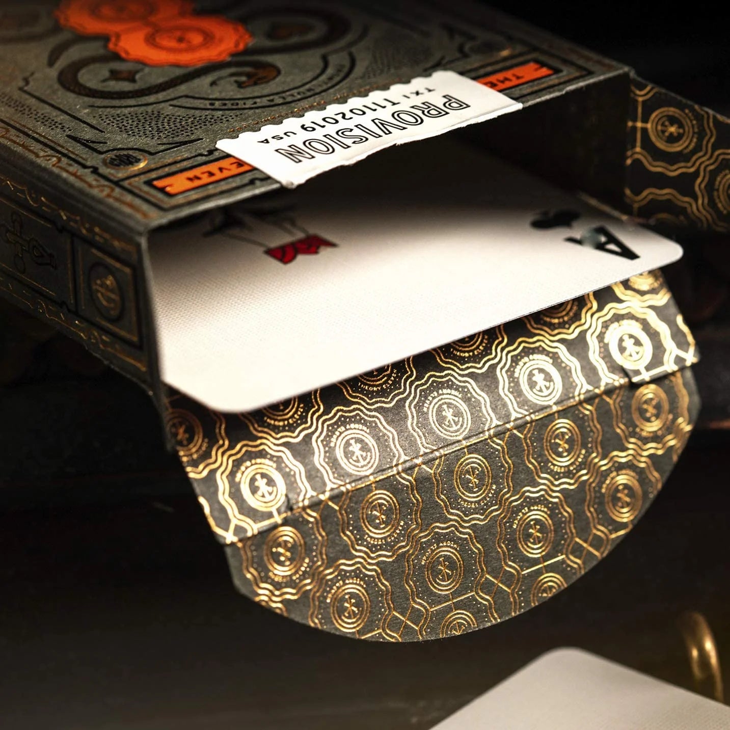 Playing cards with gold and black design on a dark background