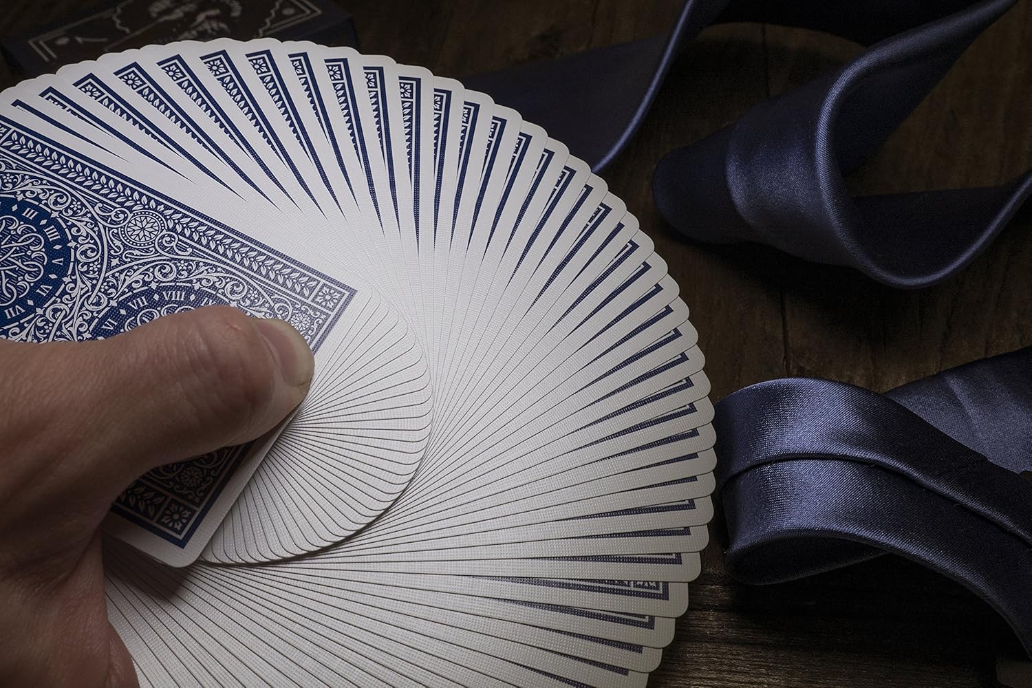 Fanned-out deck of playing cards with a blue and white design on a wooden surface.