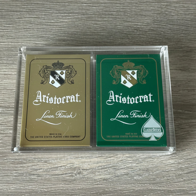 Aristocrat 727 Currency Green & Gold playing card decks in X2 case on a wood table