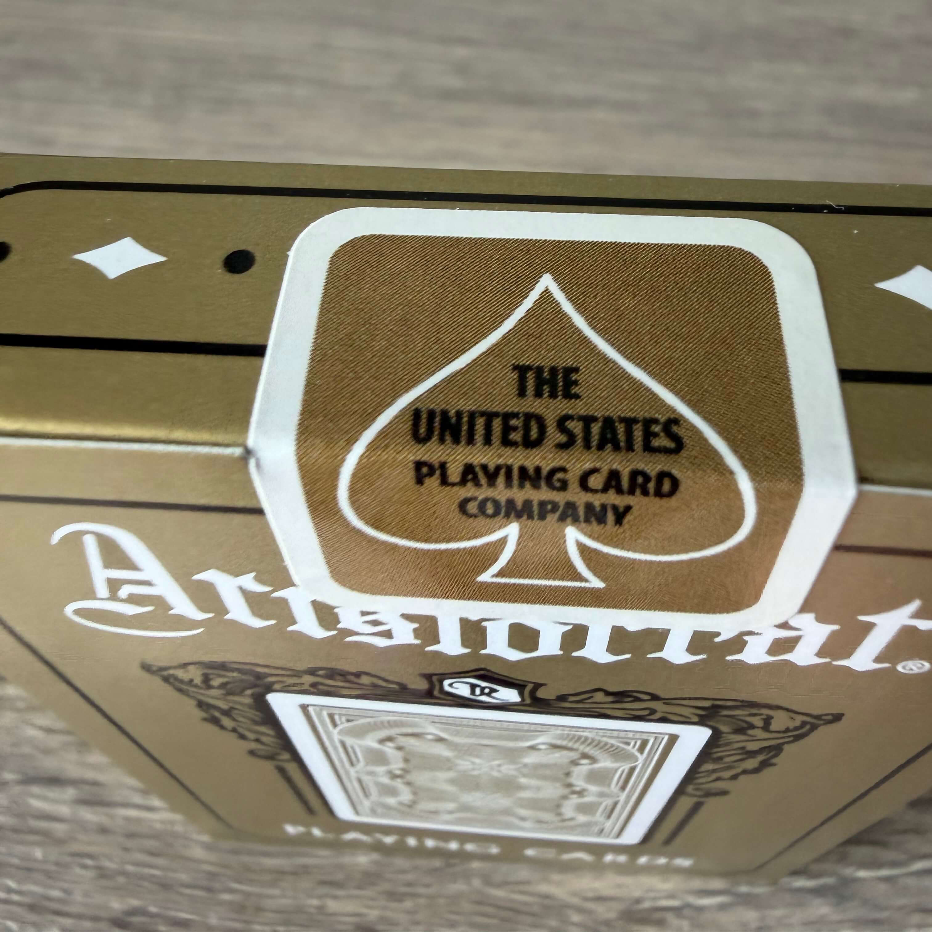 Top of Aristocrat 727 Gold tuck box with gold USPCC tax-stamp-style seal