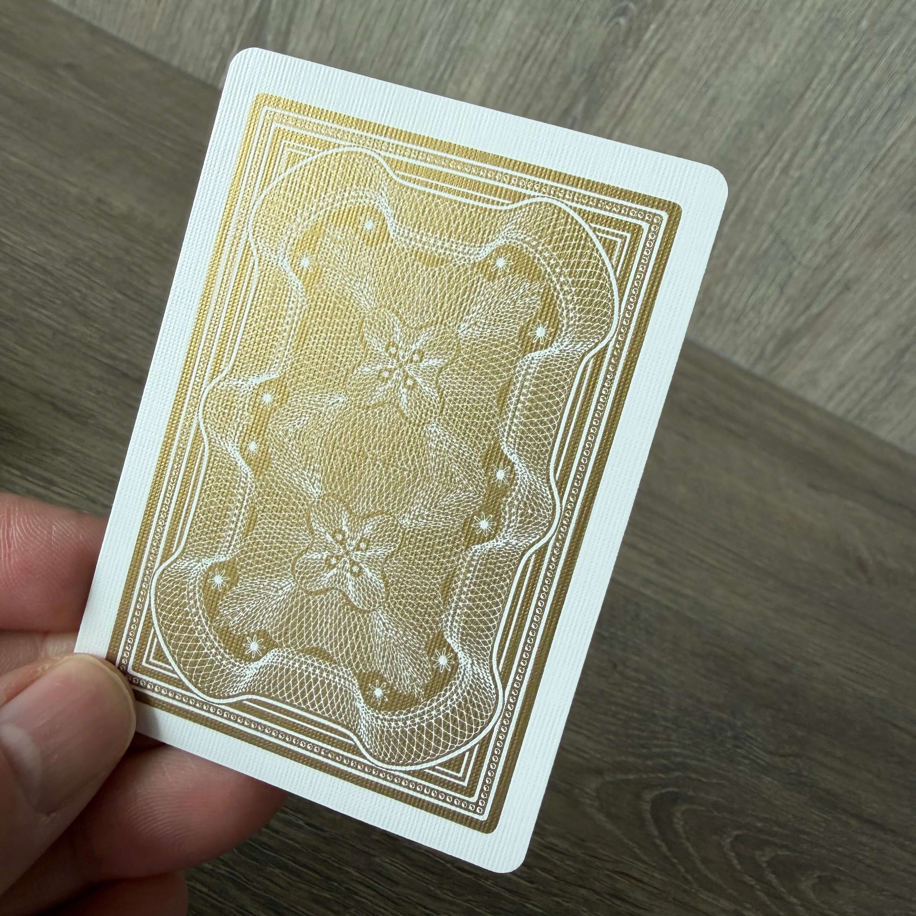 Aristocrat 727 Gold 110th Anniversary card back held in hand on wooden surface
