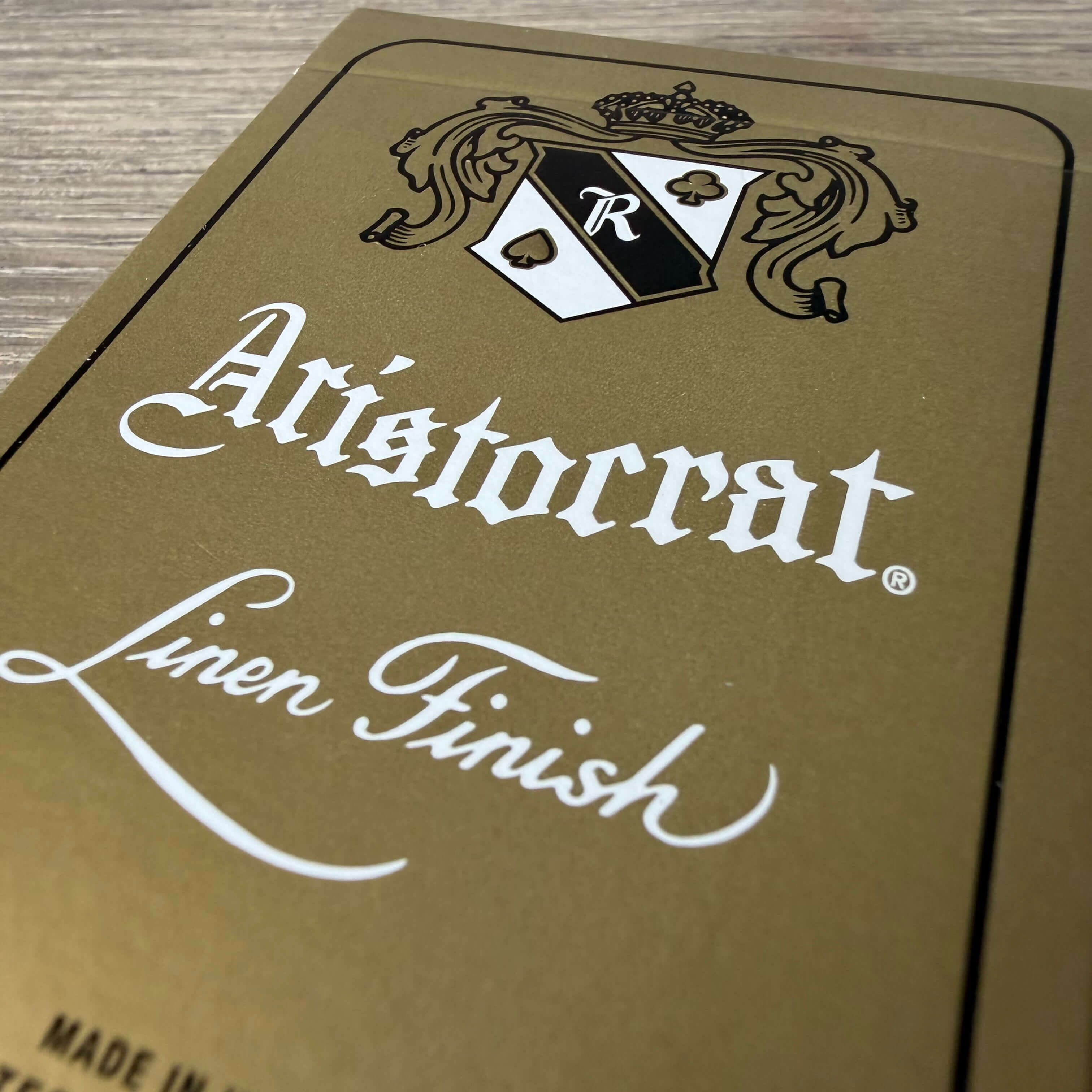 Close-up of Aristocrat 727 Gold 110th Anniversary linen finish embossing on playing card surface