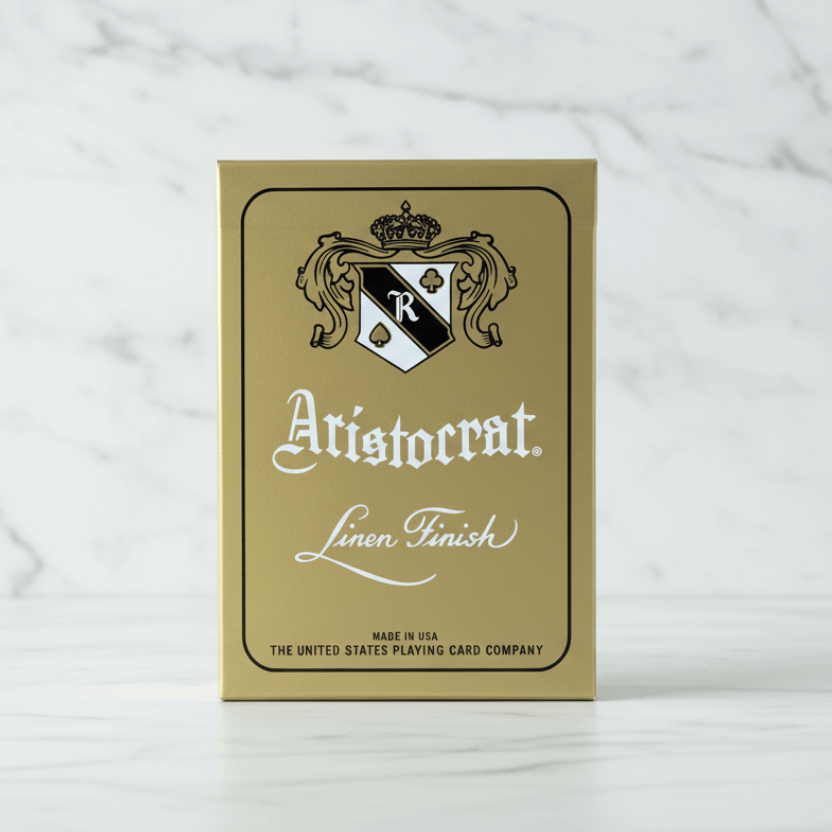 Aristocrat 727 Gold 110th Anniversary Playing Cards on marble background