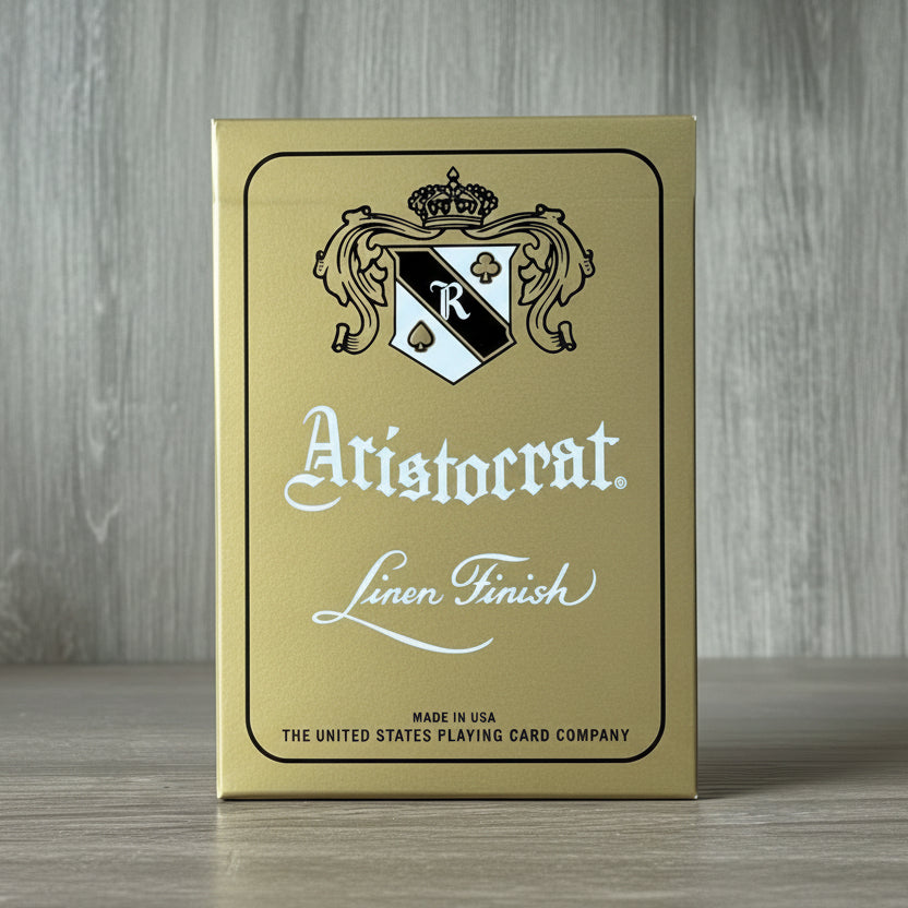Aristocrat 727 Gold 110th Anniversary tuck box on gray wood background