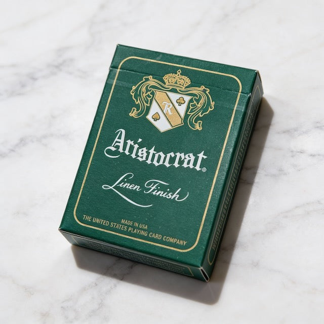 Aristocrat 727 Currency Green 110th Anniversary deck with metallic gold accents on marble surface