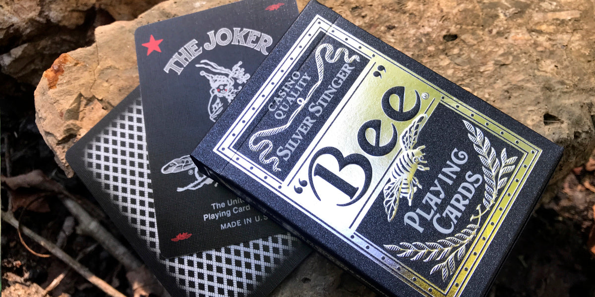 Two decks of Bee playing cards on a natural stone surface