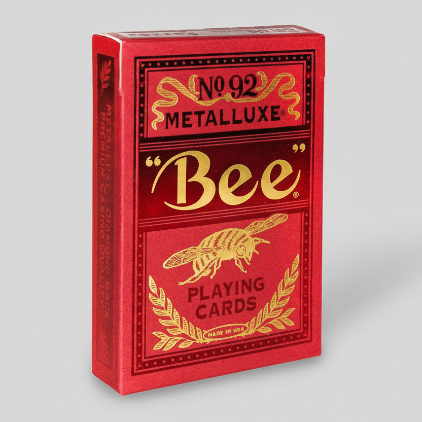 Red and gold playing card box with 'Bee' Metalluxe branding on a white background