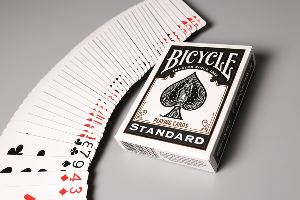 Bicycle black rider back playing cards with a deck fanned out on a gray surface