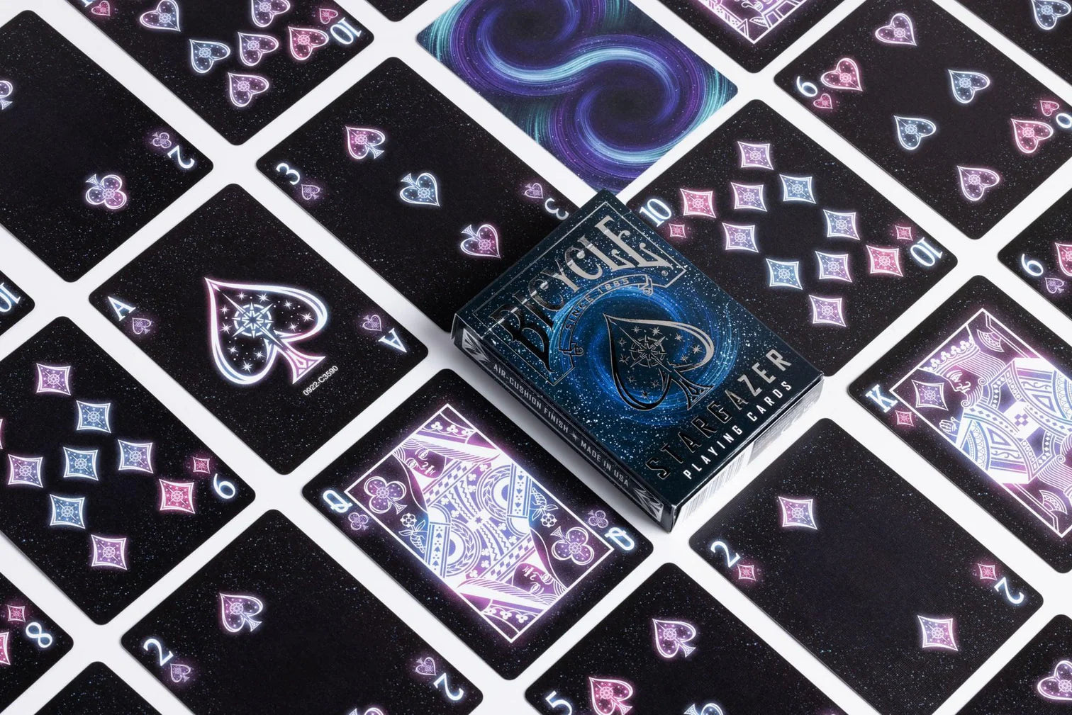 Black playing cards with colorful designs on a black surface