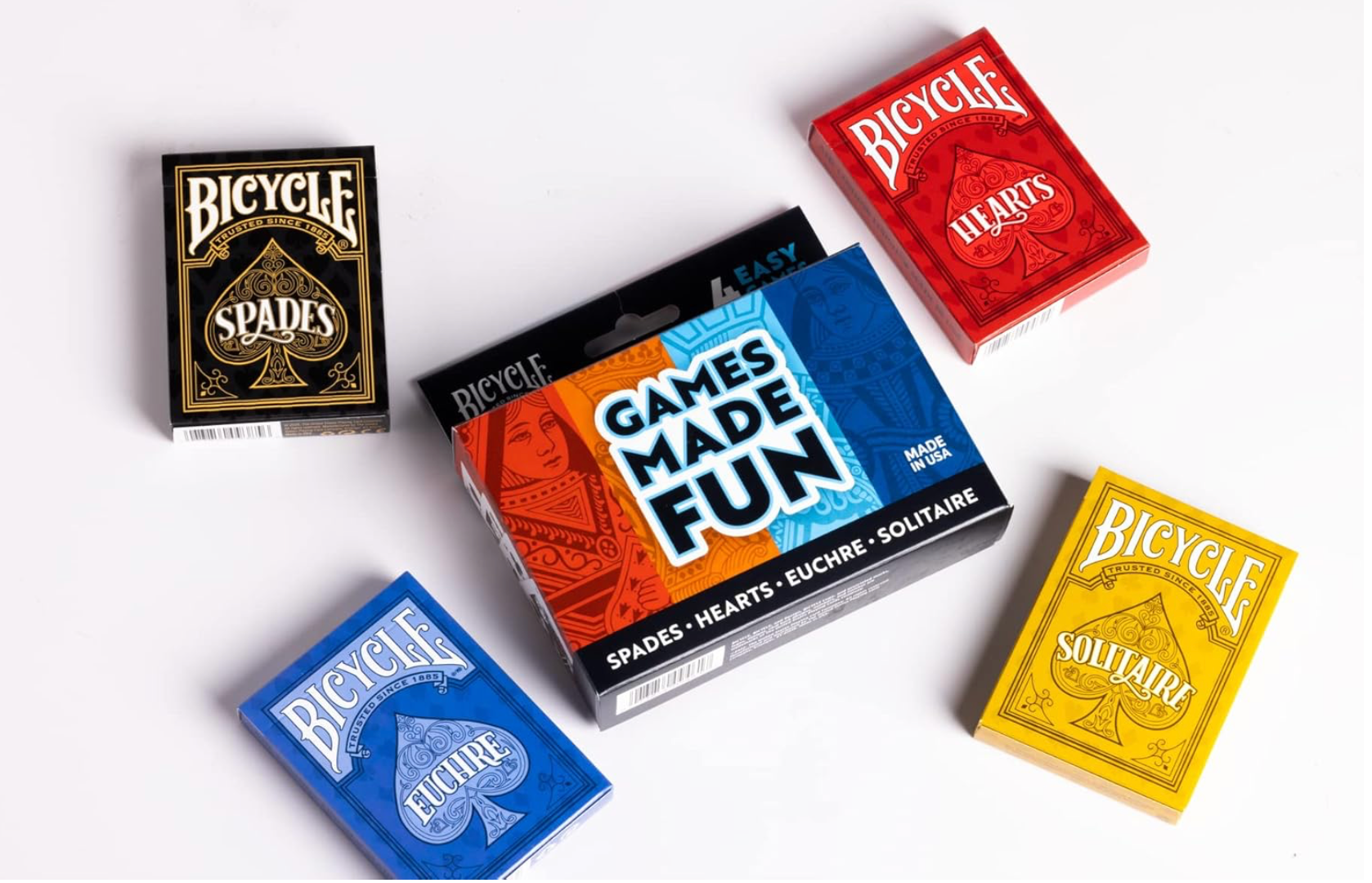 Four Bicycle playing card decks in different colors on a white background