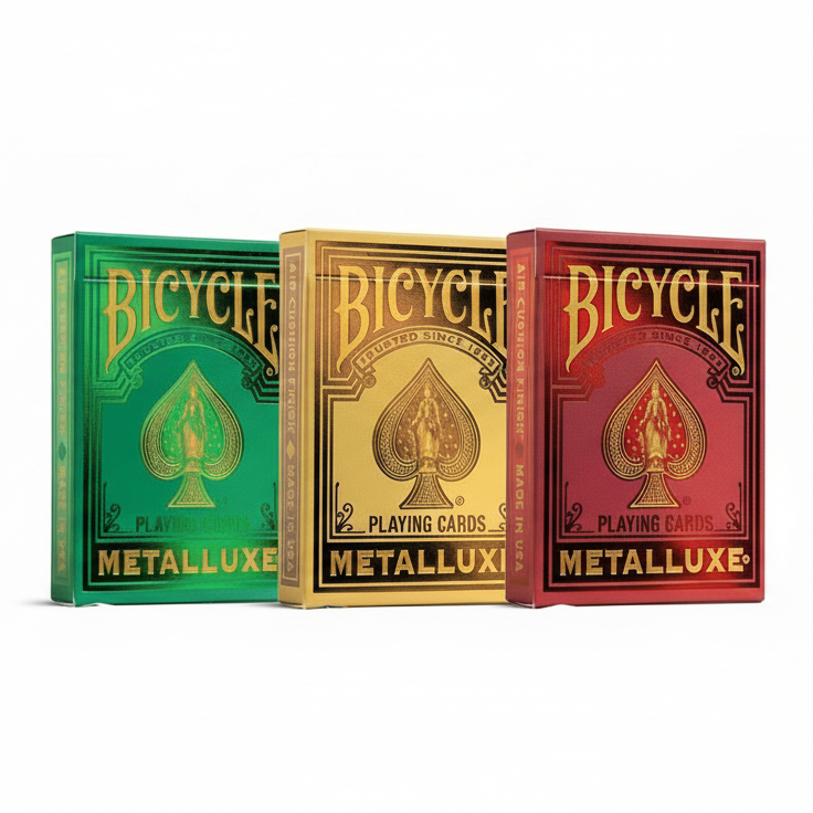 Three Bicycle Metalluxe playing card boxes in green, gold, and red.