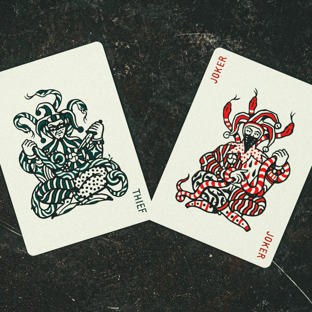 Two playing cards, one labeled 'Thief' and the other 'Joker', on a dark surface.