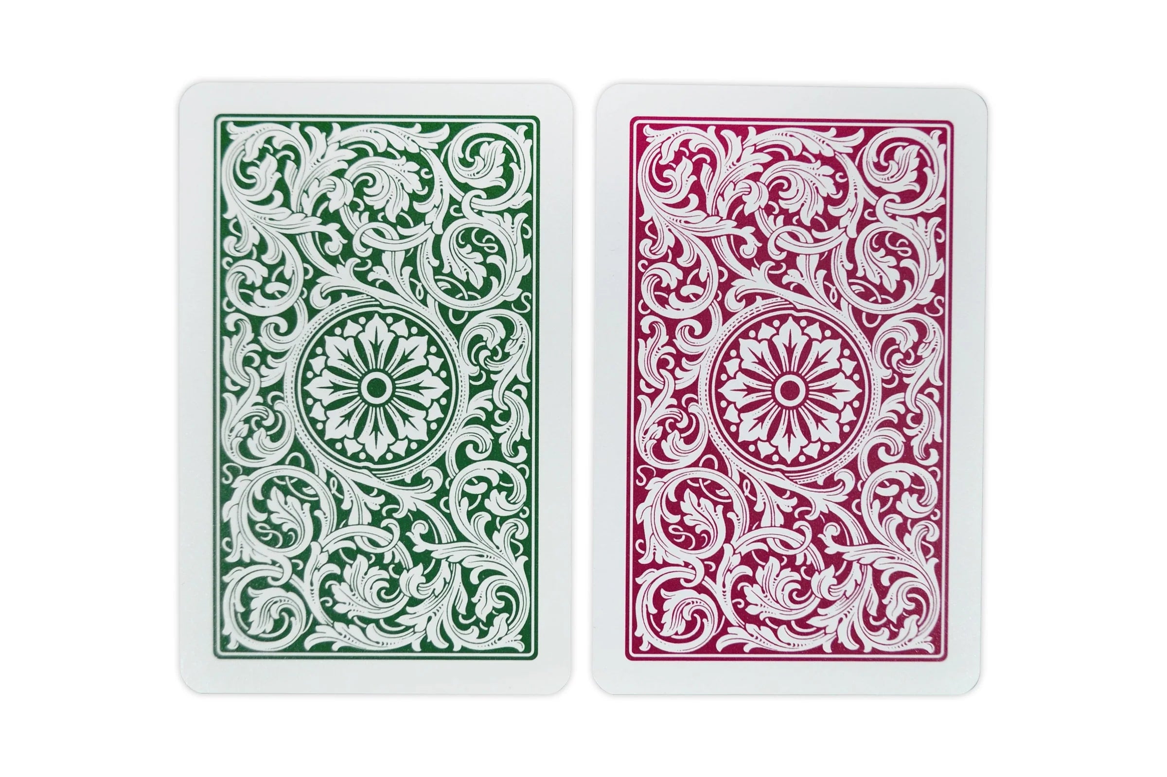 Close-up of Copag 1546 bridge cards showing green and burgundy backs side by side with intricate floral scrollwork pattern.