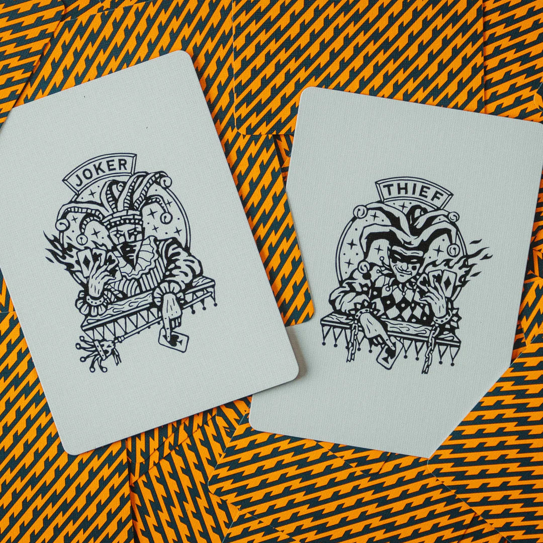 Two playing cards with 'Joker' and 'Thief' illustrations on a patterned background