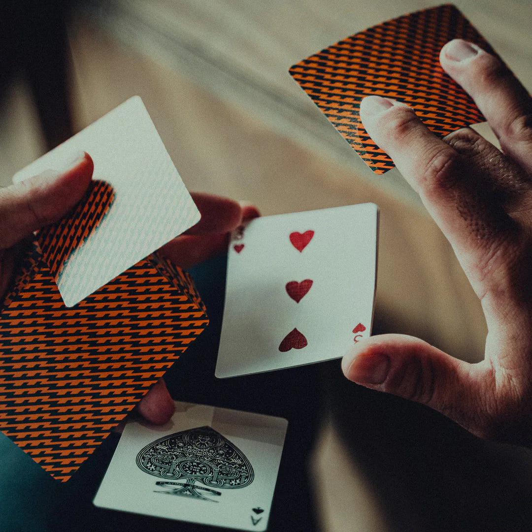 Close-up of hands holding NO BORDERS: Series 1 playing cards with a focus on the cards' designs.