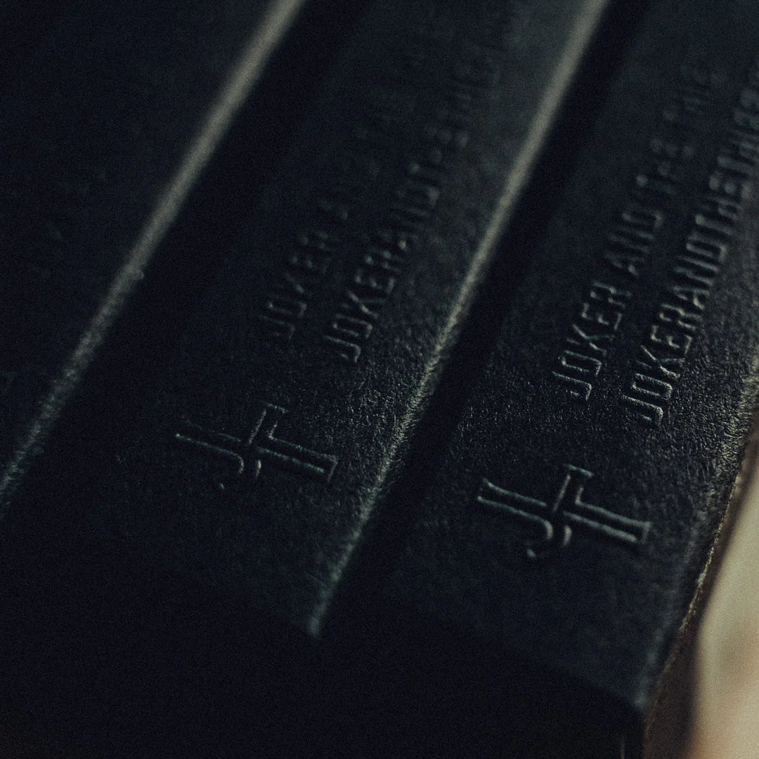 Close-up of black leather-bound books with embossed text and a cross symbol.