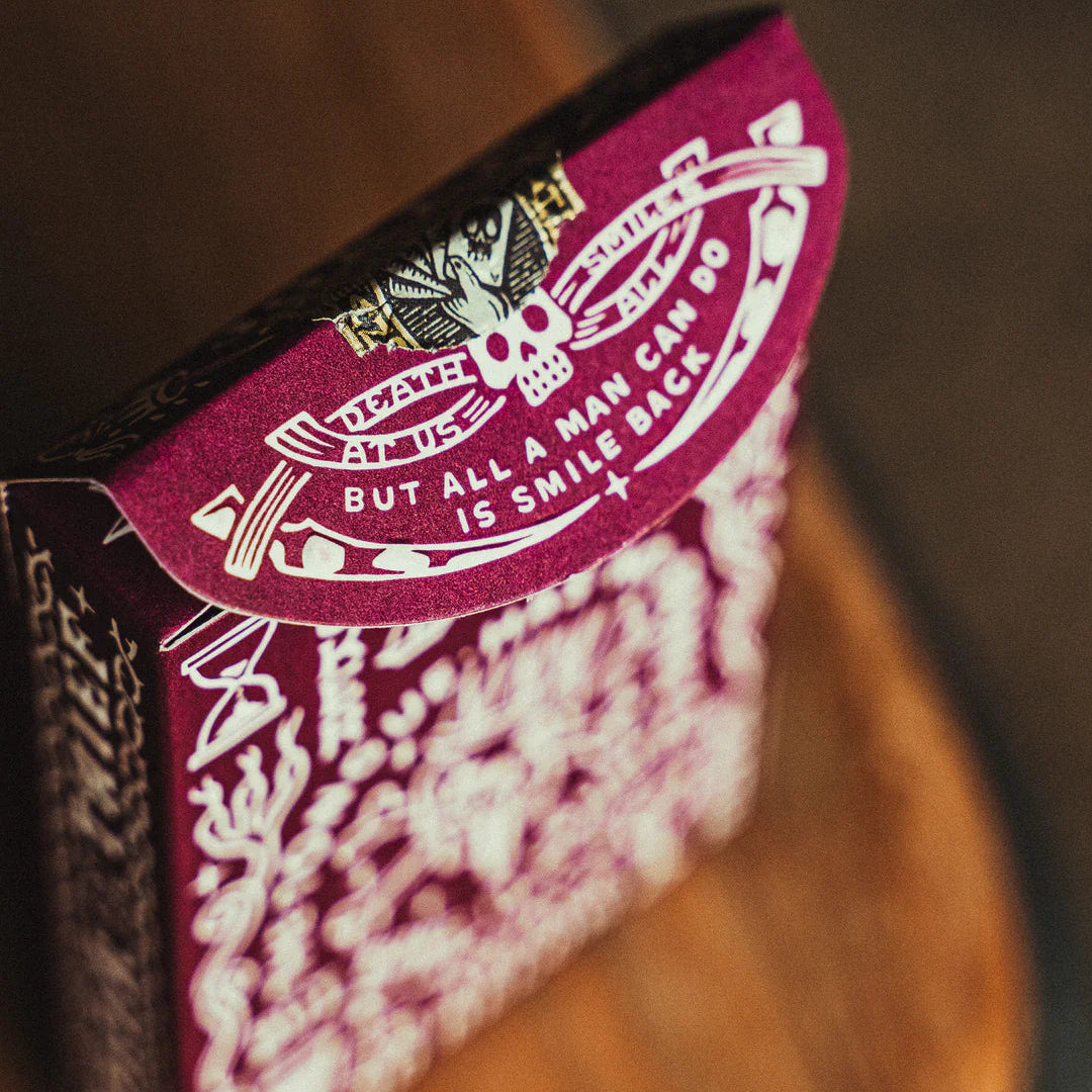 Close-up of a Crown: Royal Purple Edition playing card with intricate design and text on a wooden surface