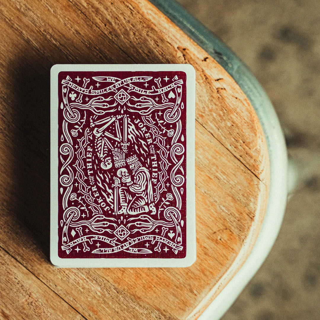 Crown: Royal Purple Edition Playing card with intricate design on a wooden surface