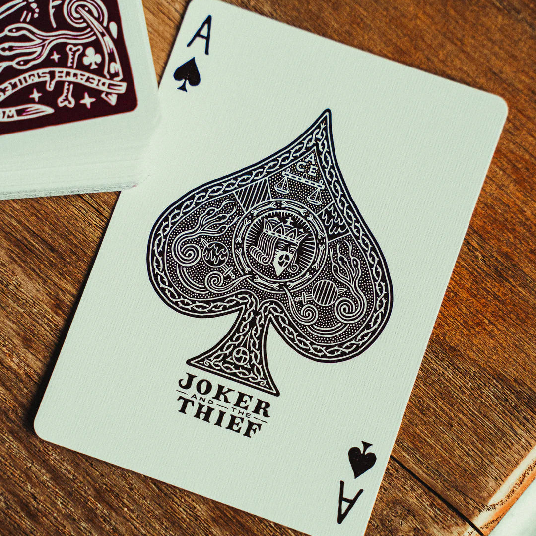 Playing card with Joker and Thief branding on a wooden surface