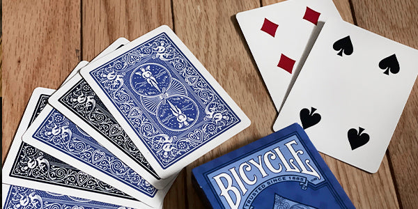Bicycle Euchre playing cards with blue and white design on a wooden surface