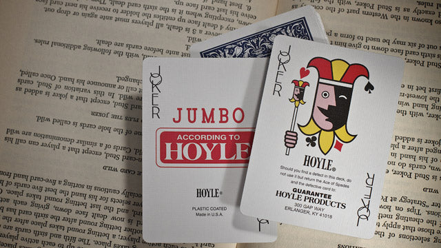 Two playing cards with 'According to Hoyle' branding on a textured surface.
