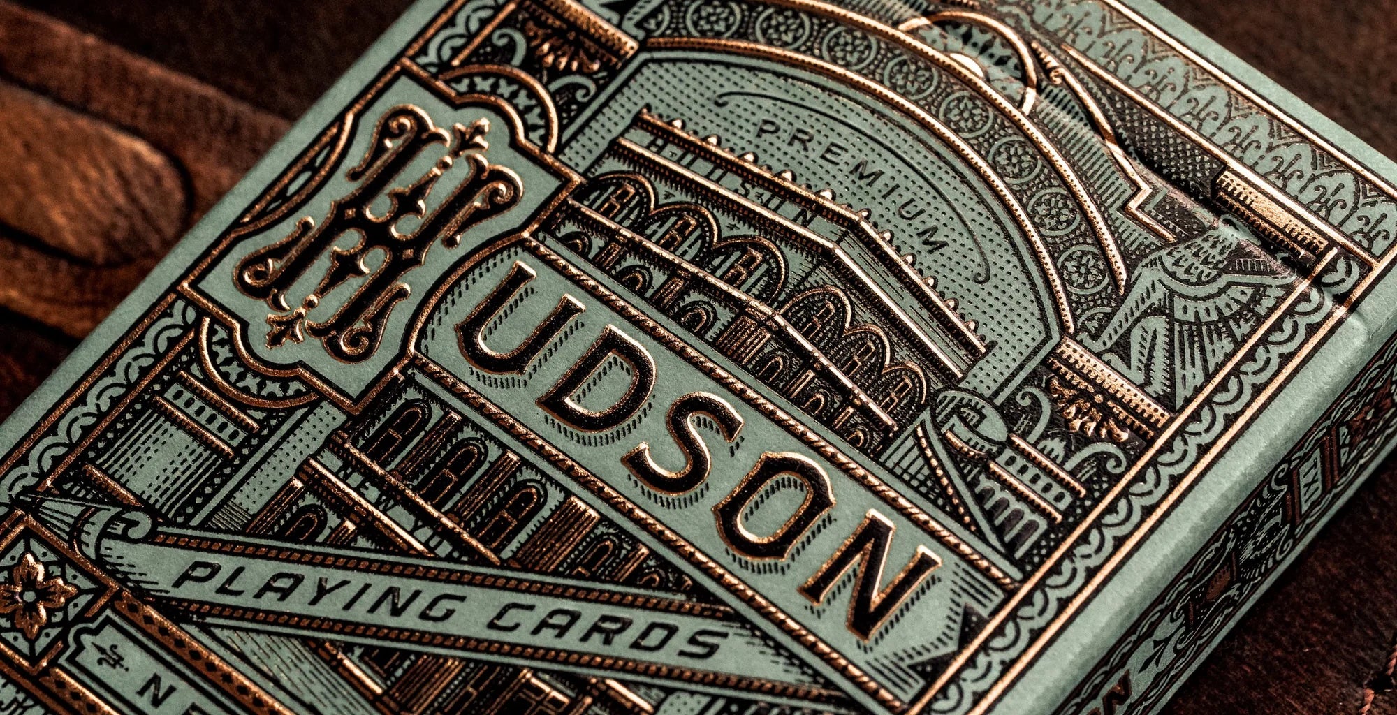 Close-up of Theory11 Hudson tuck front showing embossed copper foil and building artwork