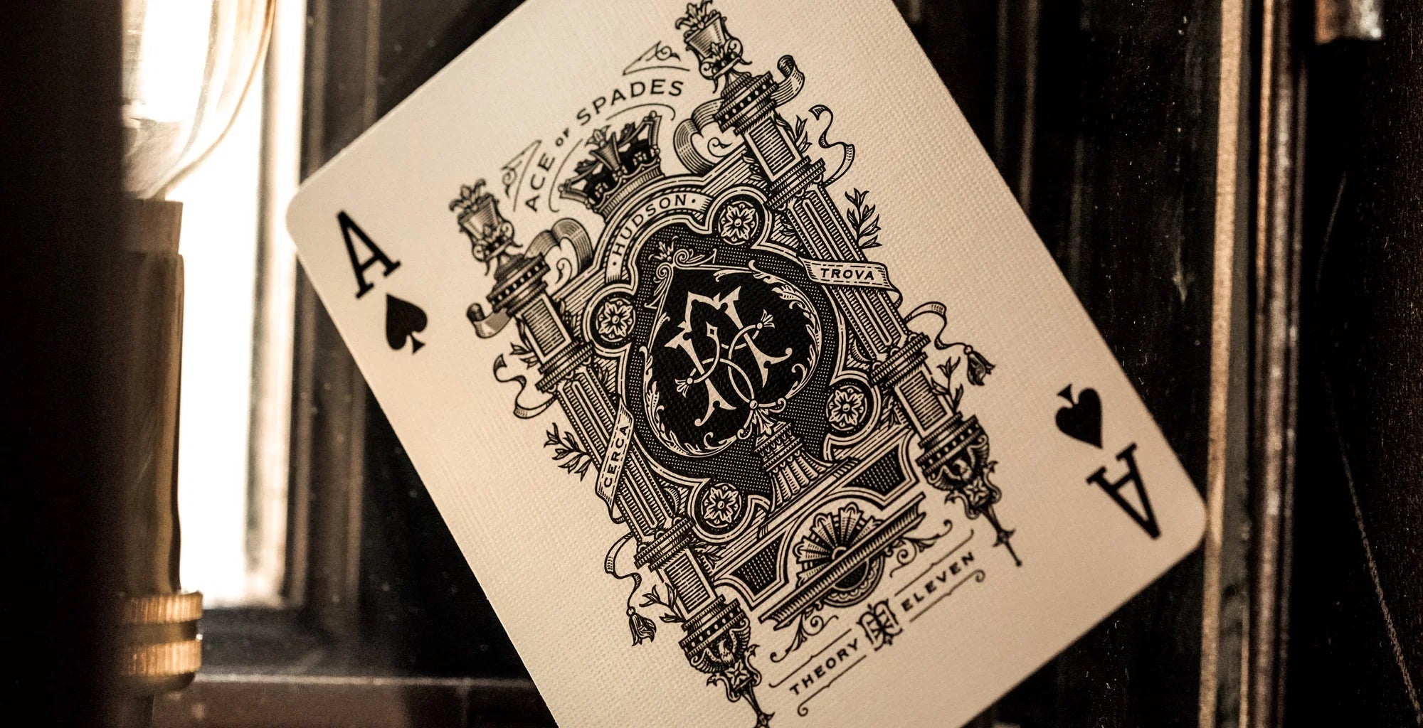 Theory11 Hudson Ace of Spades card with ornate black illustration beside a lamp
