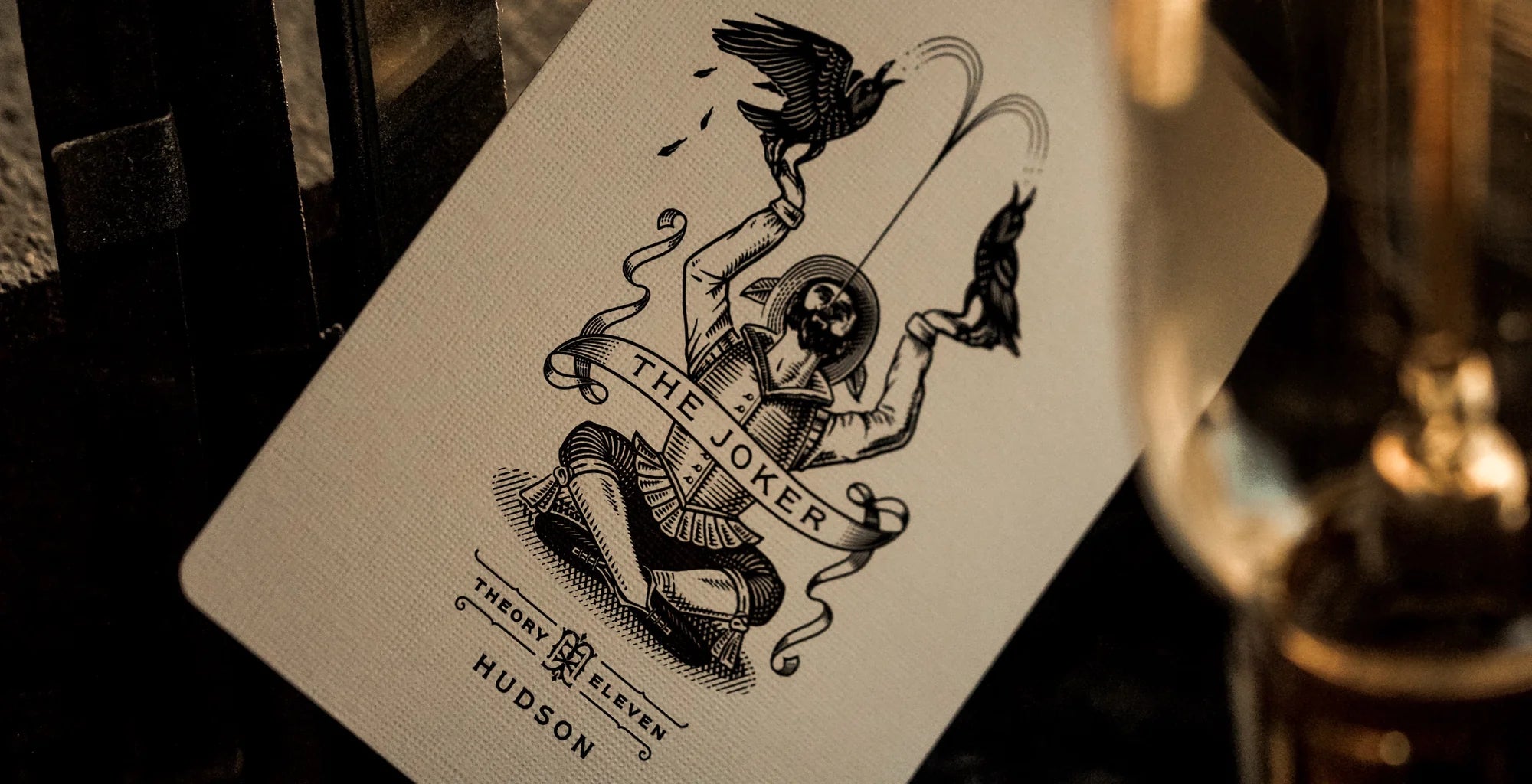 Theory11 Hudson Joker card with bird illustration beside an antique lamp