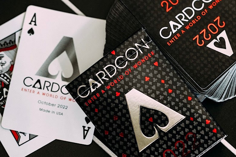 Playing cards with Cardcon branding and design on a black background