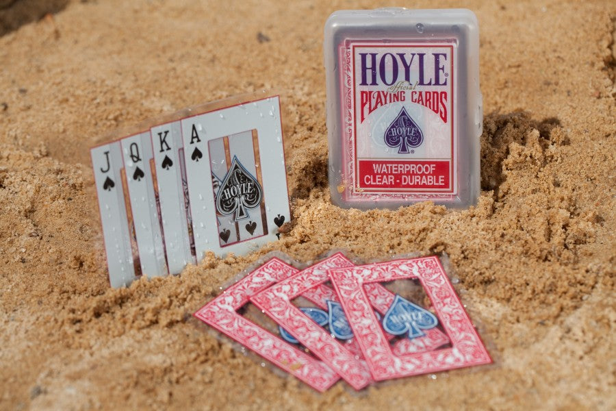 Playing cards with 'Hoyle' branding on a sandy background