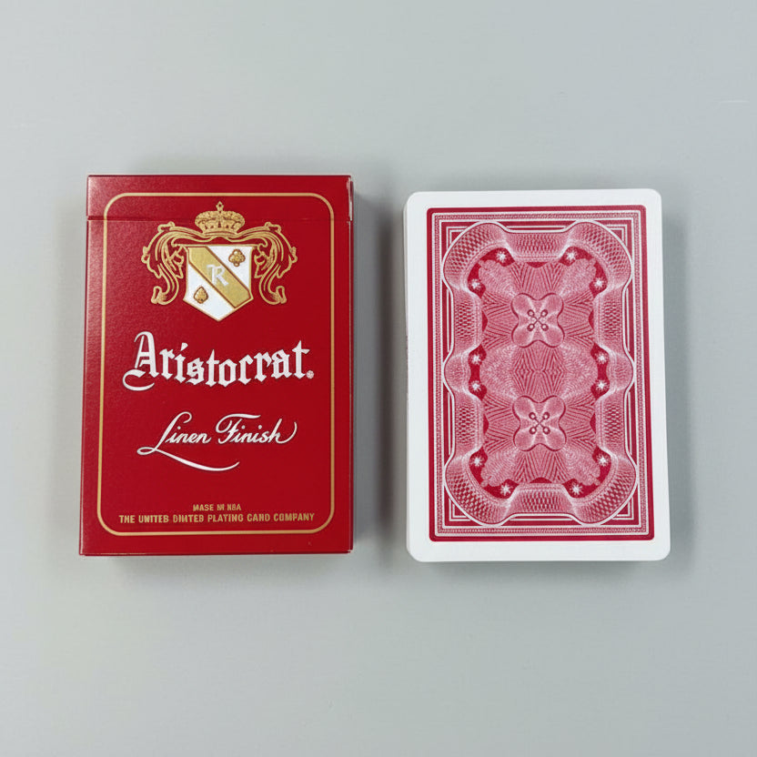 Aristocrat 727 Currency Green 110th Anniversary Playing Cards tuck box and stack of cards showing card backs on a grey surface