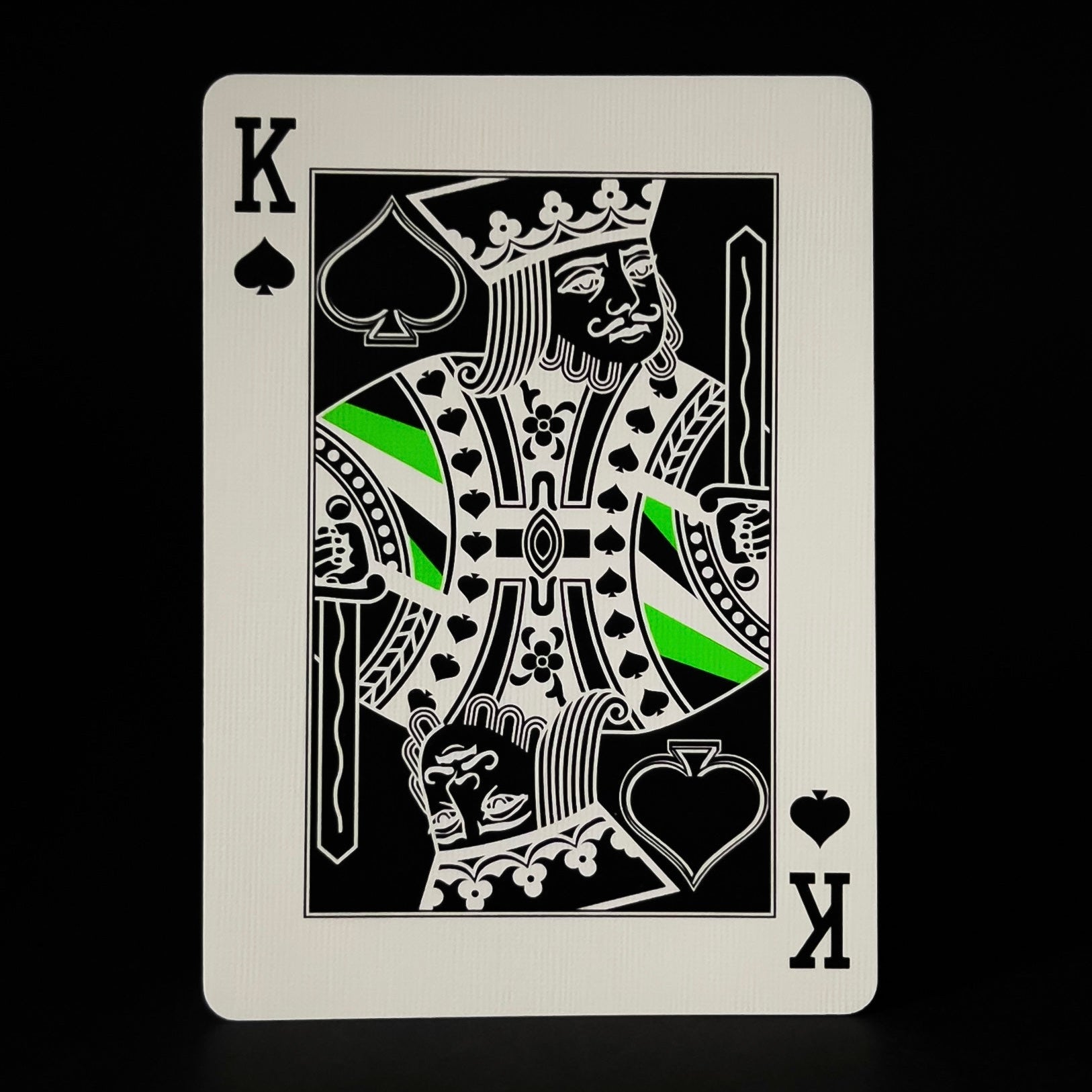 King of Spades Desecendents playing card with green accents on a black background