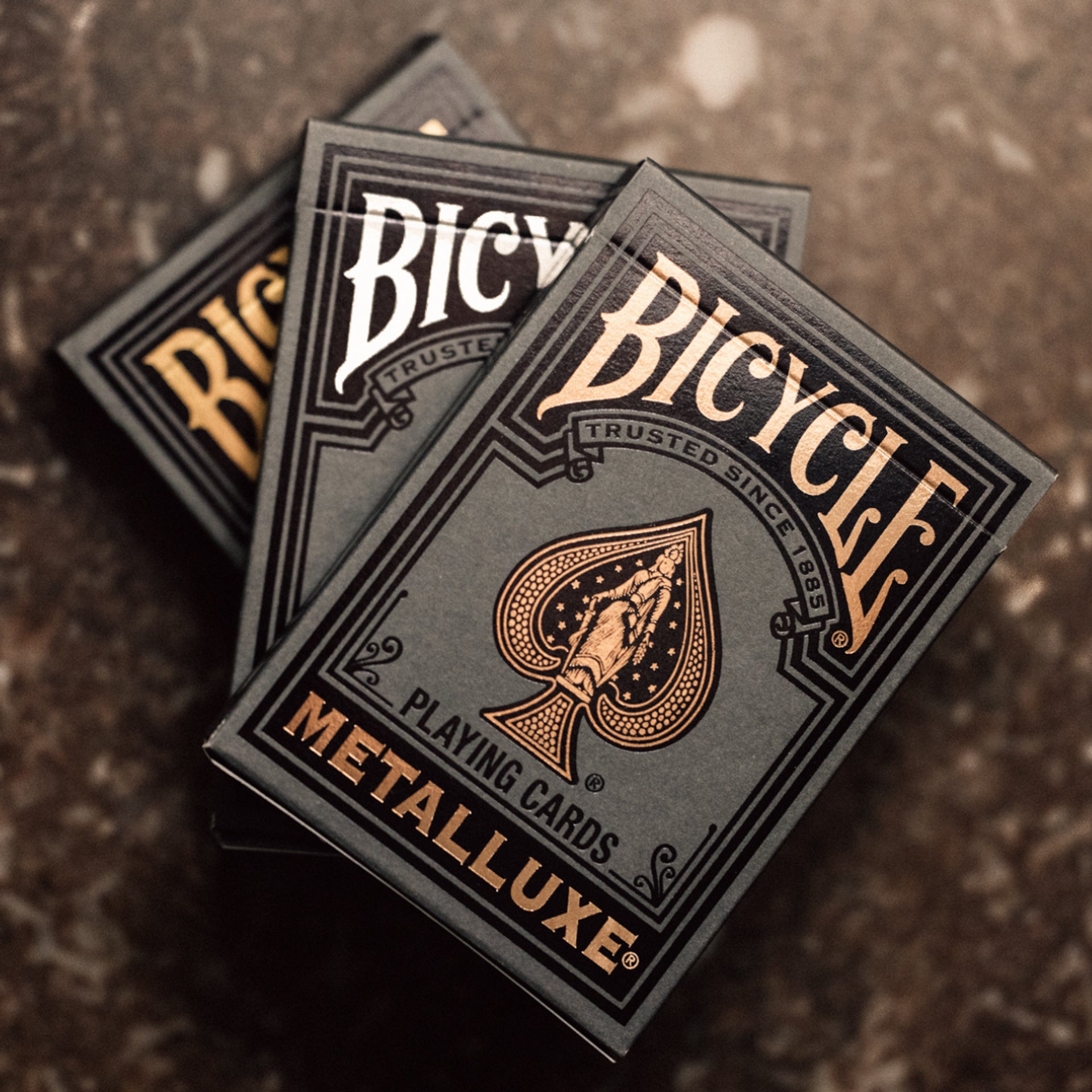 Bicycle Black Metalluxe playing cards on a textured surface