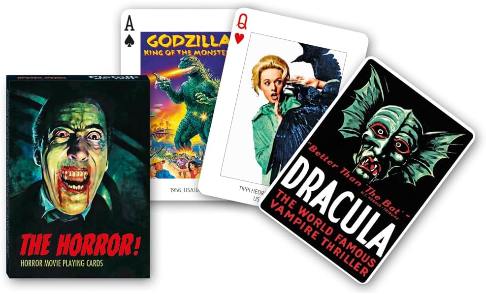 Close‑up of Piatnik The Horror! tuck box with vampire artwork alongside cards featuring Godzilla, The Birds, and Dracula poster designs.