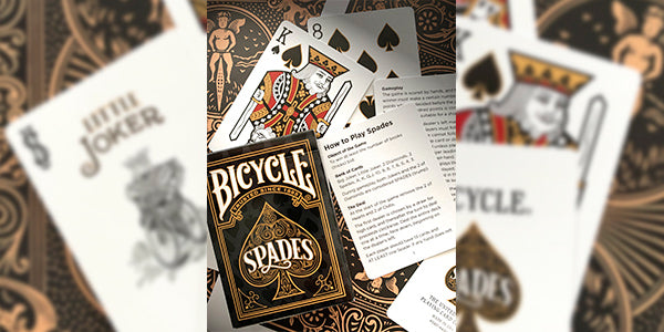 Bicycle Spades playing cards with joker card and instructions on a decorative background