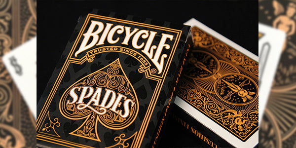Bicycle Spades playing cards with ornate design on a black background