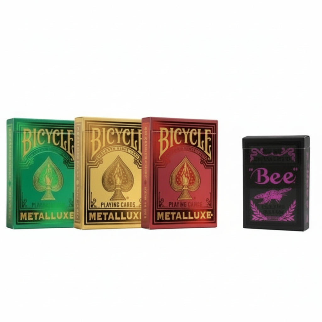 Three Bicycle Metalluxe playing card boxes in green, gold, and red, with a black 'Bee' box on a gray background.