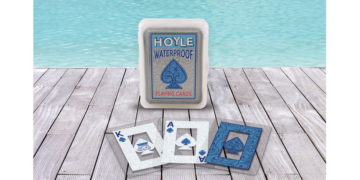 Hoyle Waterproof playing cards packaging on a wooden surface with a blue watercolor background