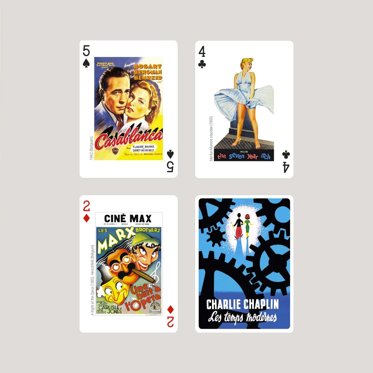 Four Piatnik playing cards with movie-themed designs on a gray background