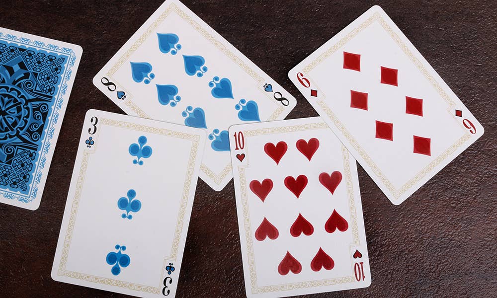 Four playing cards on a dark surface