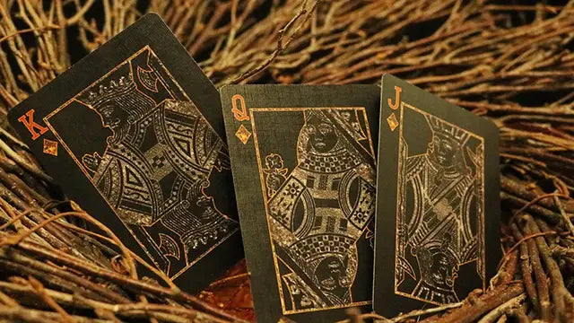 Black playing cards with gold designs on a rustic background