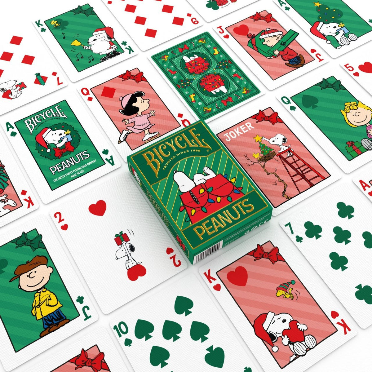 Bicycle Peanuts Holiday tuck box among Christmas character courts, a wreath-themed Ace of Spades, a Snoopy Joker, number cards, and a card back.